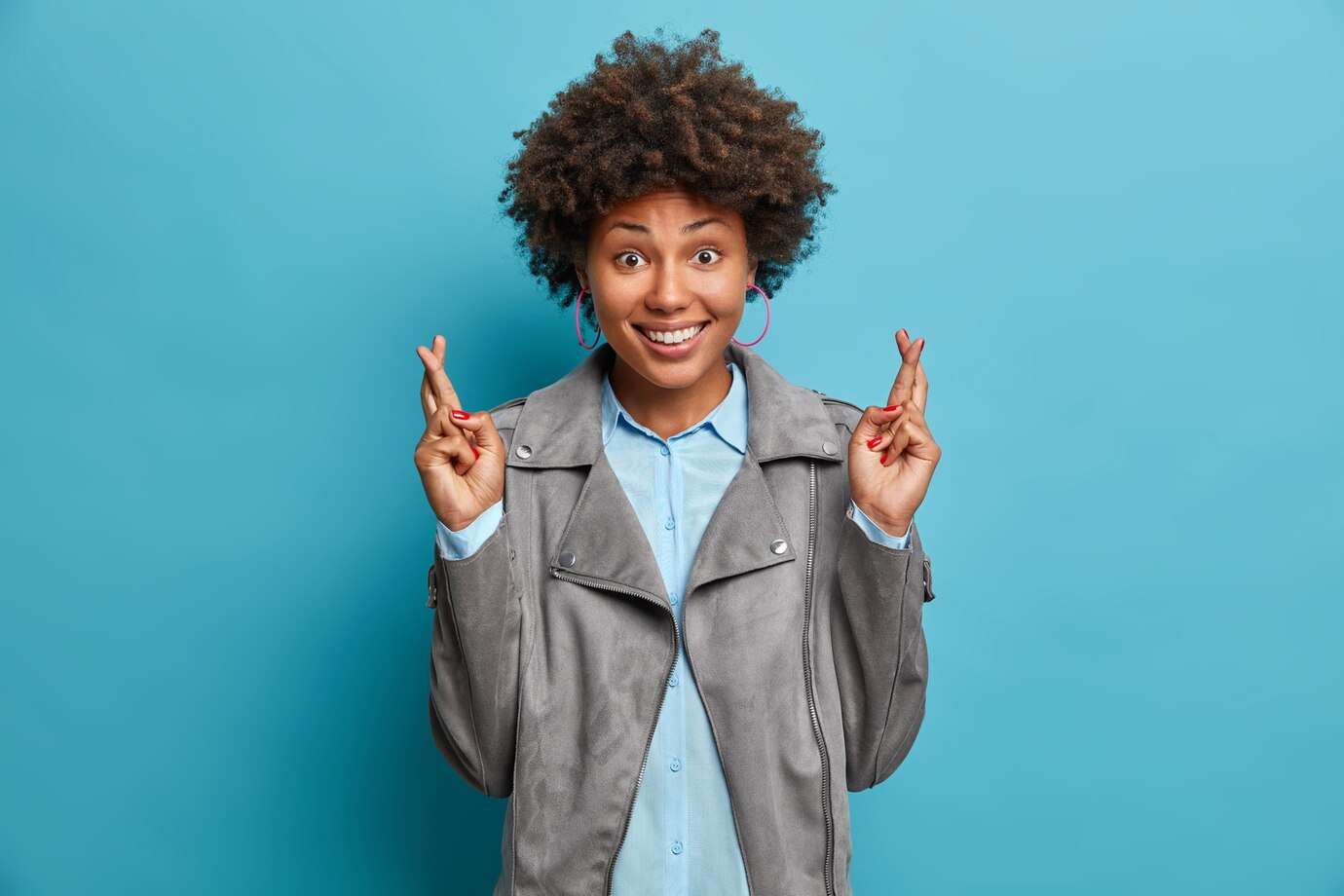happy-student-with-afro-hairstyle-hopes-pass-exam-successfully-crosses-fingers-good-luck-makes-wish-anticipates-positive-results-wears-fashionable-clothes-poses_273609-43343